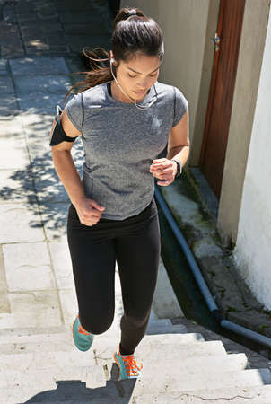 Getting in some great cardio. Shot of a fit young woman running up a flight of stairs.