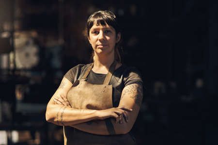 Im kind of a legend in the blacksmithing business. Portrait of a confident young woman working at a foundry.の写真素材