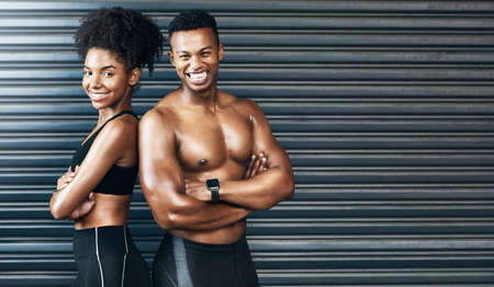 Make today count towards a better tomorrow. Portrait of a sporty young couple standing together against a grey background.の写真素材