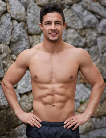 Proud of the body Ive built. Portrait of a handsome young man standing with his hands on his hips...