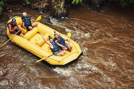 Life is either a daring adventure or nothing at all. Shot of a group of friends out river rafting on a sunny day.の写真素材