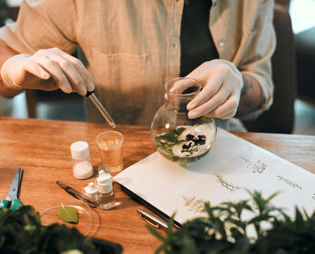 One tiny dosage does a world of good here. Cropped shot of an unrecognizable botanist adding a...