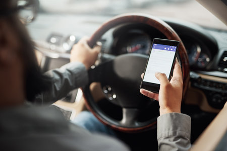 Texting and driving an accident waiting to happen. Shot of a man using his phone while driving.