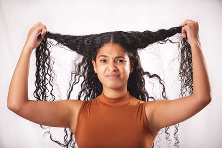 Should I do something else with it. Shot of a young woman with long brown hair posing in the studio.
