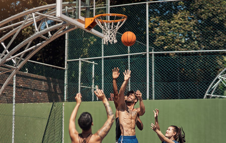 Will he make the shot. Shot of a group of sporty young people playing basketball on a sports court.