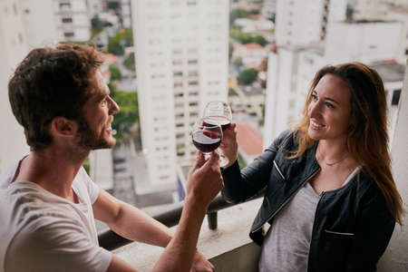 Celebrating our adventure through the city. Cropped shot of an attractive young couple drinking wine...