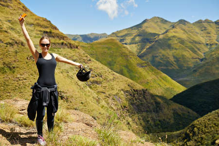 Energized by the fresh air. A young woman standing in the mountainside.の写真素材