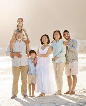 Always make time for your family. Full length shot of a happy diverse multi-generational family at the beach.の写真素材