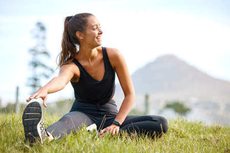 Make sure you always start with a really good stretch. Shot of a sporty young woman stretching her...
