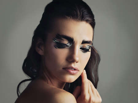 I like to be a little different. Studio shot of an attractive young woman wearing bold eye makeup.の写真素材