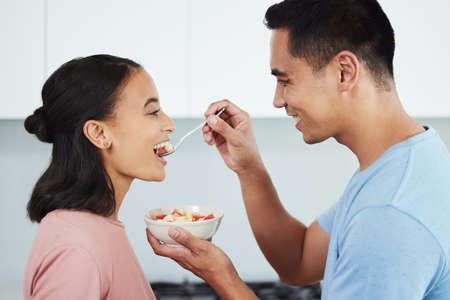 Keeping it fresh and healthy. Shot of a husband feeding his wife food.