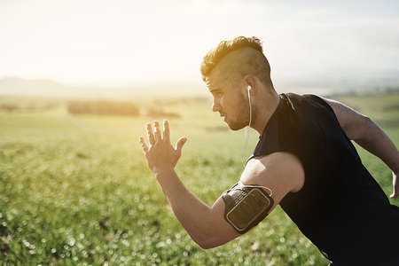 Focused on the road ahead. Cropped shot of a handsome young man running outdoors.の写真素材