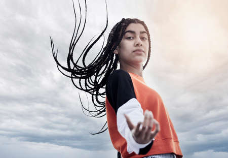 Come at me. Low angle portrait of an attractive young woman dancing against a stormy backdrop.