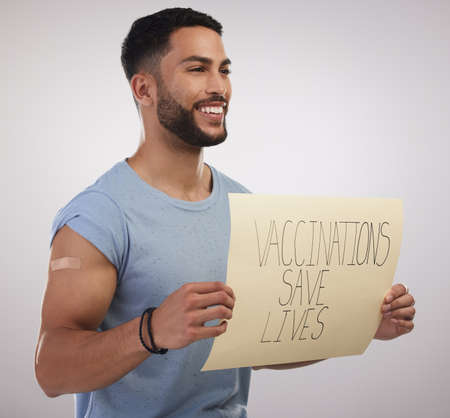 I fully support getting vaccinated. Shot of a handsome young man sitting alone in the studio and...
