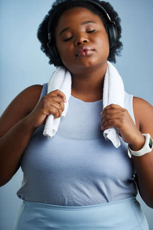 At peace with her personal progress. Studio shot of an athletic young woman posing against a blue background.の写真素材
