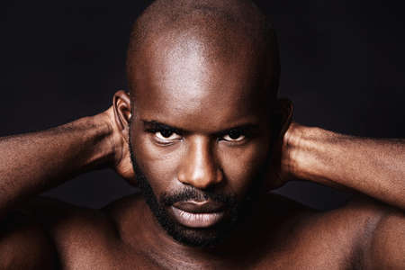 Ready for anything. Studio shot of a muscular african american man against a black background.
