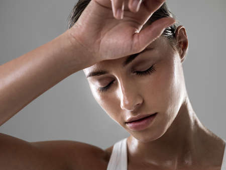 Total exhaustion, the sign of a great workout. Shot of an attractive woman looking tired after a good workout.の写真素材