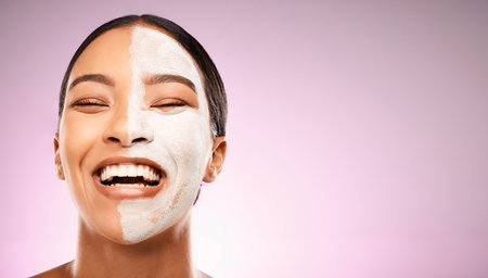When youre truly happy, youre truly beautiful. Studio shot of an attractive young woman having a facial against a pink background.の写真素材