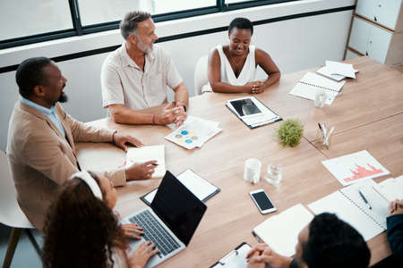 Its always good to catch up with my team. Shot of a group of businesspeople having a meeting at...