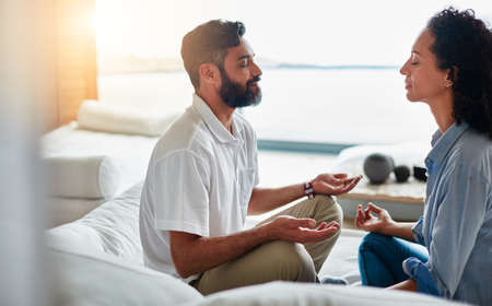 Finding their zen together. Shot of a relaxed couple meditating together at home.の写真素材