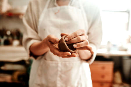 I create objects from earthenware materials. Cropped shot of a woman shaping a clay pot in her workshop.の写真素材