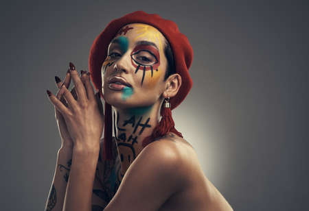 Theres beauty in our differences. Studio shot of a young woman posing with paint on her face on a...