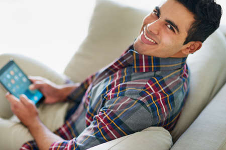Theres nothing more convenient than a tablet. Portrait of a handsome young man using his tablet...
