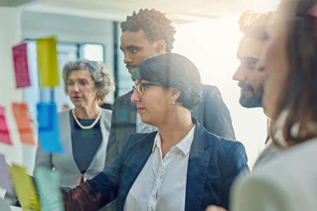 Organising every detail together. Cropped shot of a group of businesspeople brainstorming with...