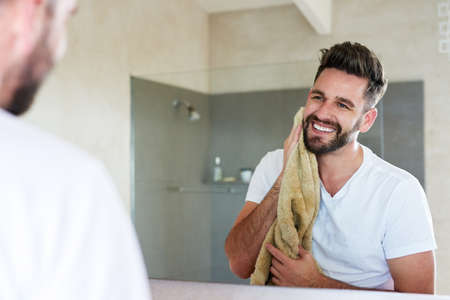 Cleanliness is next to godliness. Cropped shot of a handsome young man going through is morning routine in the bathroom.の写真素材