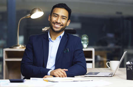 This industry is tough but worthwhile. Shot of a young male stock broker at his desk.