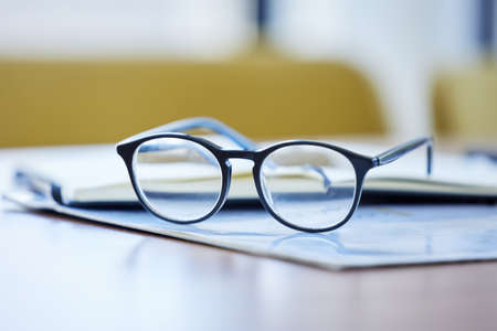Being a visionary is ones greatest strength. Shot of glasses and paperwork lying on a desk in an empty office during the day.の写真素材
