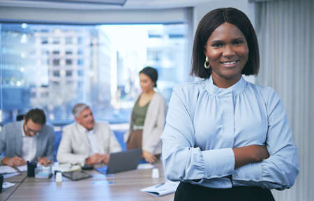 Stay focused and keep it moving. Shot of a beautiful businesswoman standing in a boardroom during a meeting.の写真素材