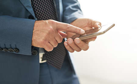 Always connected. Closeup shot of a businessman texting on a cellphone.の写真素材