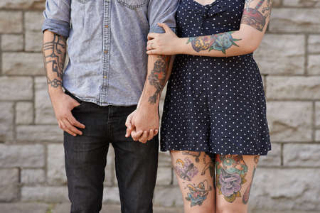Their bodies are the pages to their love story. Cropped shot of a couple with tattoos on their bodies.の写真素材