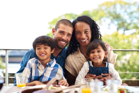 Love is the glue that keeps us all together. Portrait of a beautiful young family enjoying a meal...