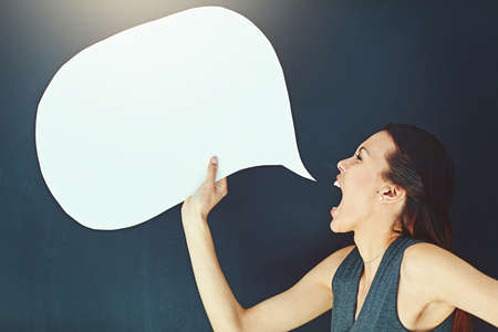 Sometimes youve just gotta let it out. Shot of a young woman shouting with a speech bubble against a...