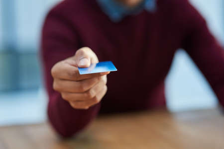 No charge too big or small to swipe for. Shot of an unidentifiable businessman holding out his credit card.の写真素材
