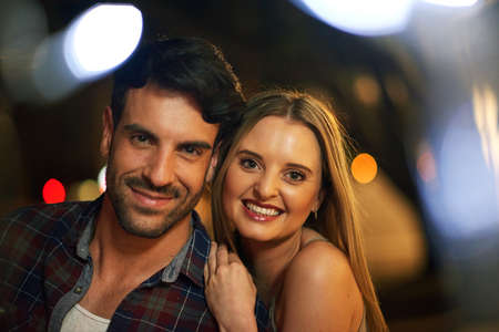 Enjoying a romantic night out. Shot of a young couple out on a date in the city.の写真素材