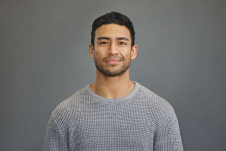 First you have to believe in yourself. Shot of a handsome young man standing against a grey...