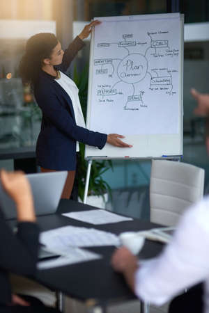 Its never too late for a good idea. Shot of a young businesswoman giving a late night presentation...