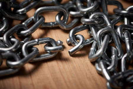 Chains are only as strong as their weakest links. Shot of metal chains with a broken link.の写真素材