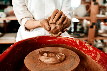 Ill never let go of my love of clay. Cropped shot of an unrecognizable woman molding clay on a...
