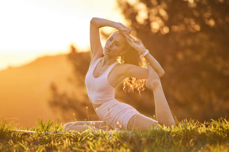 Yoga is the key to a healthy life. Full length shot of an attractive young woman practicing yoga outside on a sunny morning.の写真素材