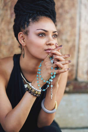 She understands the importance of prayer. Shot of an attractive young woman praying with her rosary...