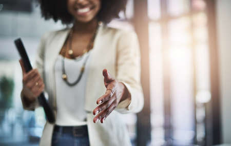 Welcome to the team, Ill show you around the office. Shot of an unrecognizable businesswoman reaching out for a handshake.の写真素材