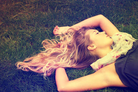 Sleeping beauty. An attractive young girl sleeping on the grass outside.の写真素材
