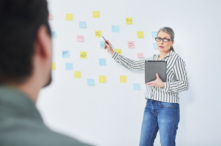 Presenting a brand new project. Shot of a mature businesswoman giving a presentation with notes on a...