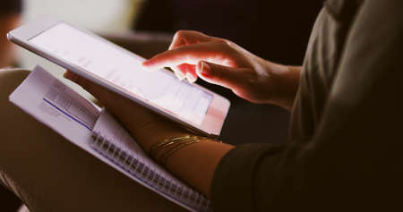 Working late with the help of modern technology. Cropped shot of an unrecognizable businesswoman...