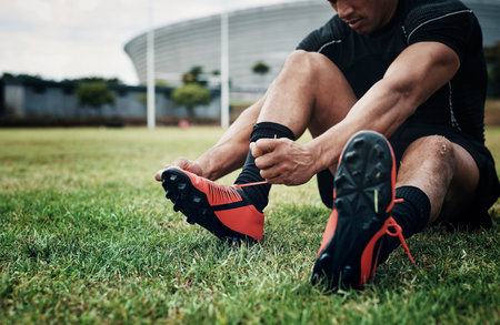 Lets get started with this training. Cropped shot of an unrecognizable rugby player tying his...
