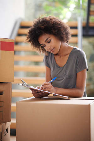 Heres to a new start. Shot of a young woman moving into her new house.